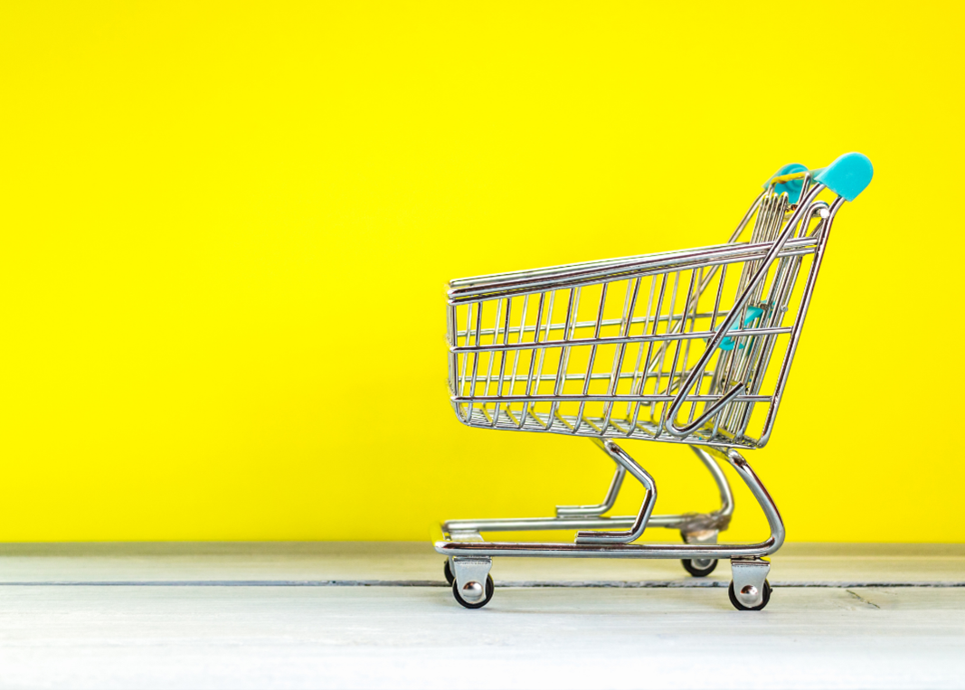 Shopping cart in front of yellow wall